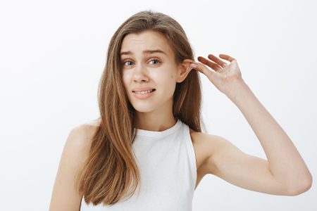 a woman touching her ears before otoplasty surgery