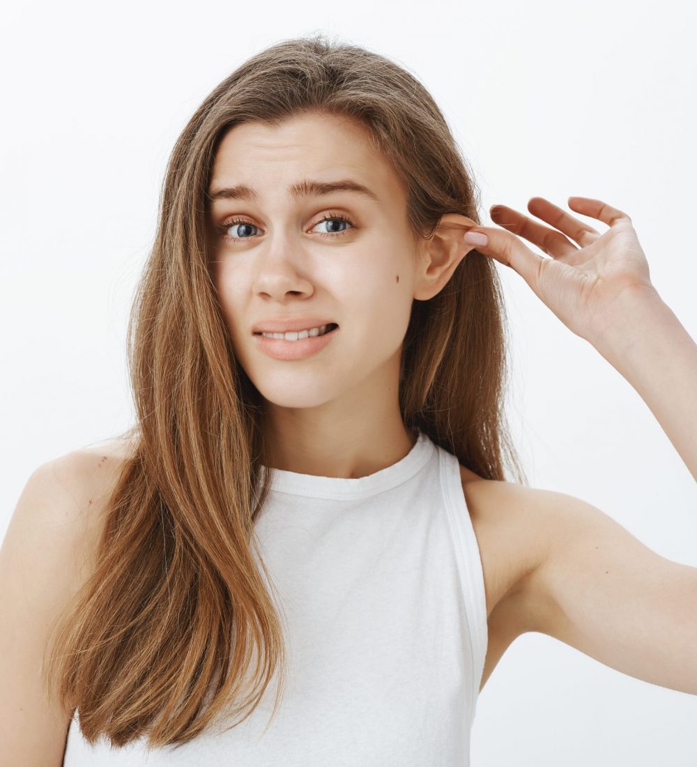 a woman touching her ears before otoplasty surgery