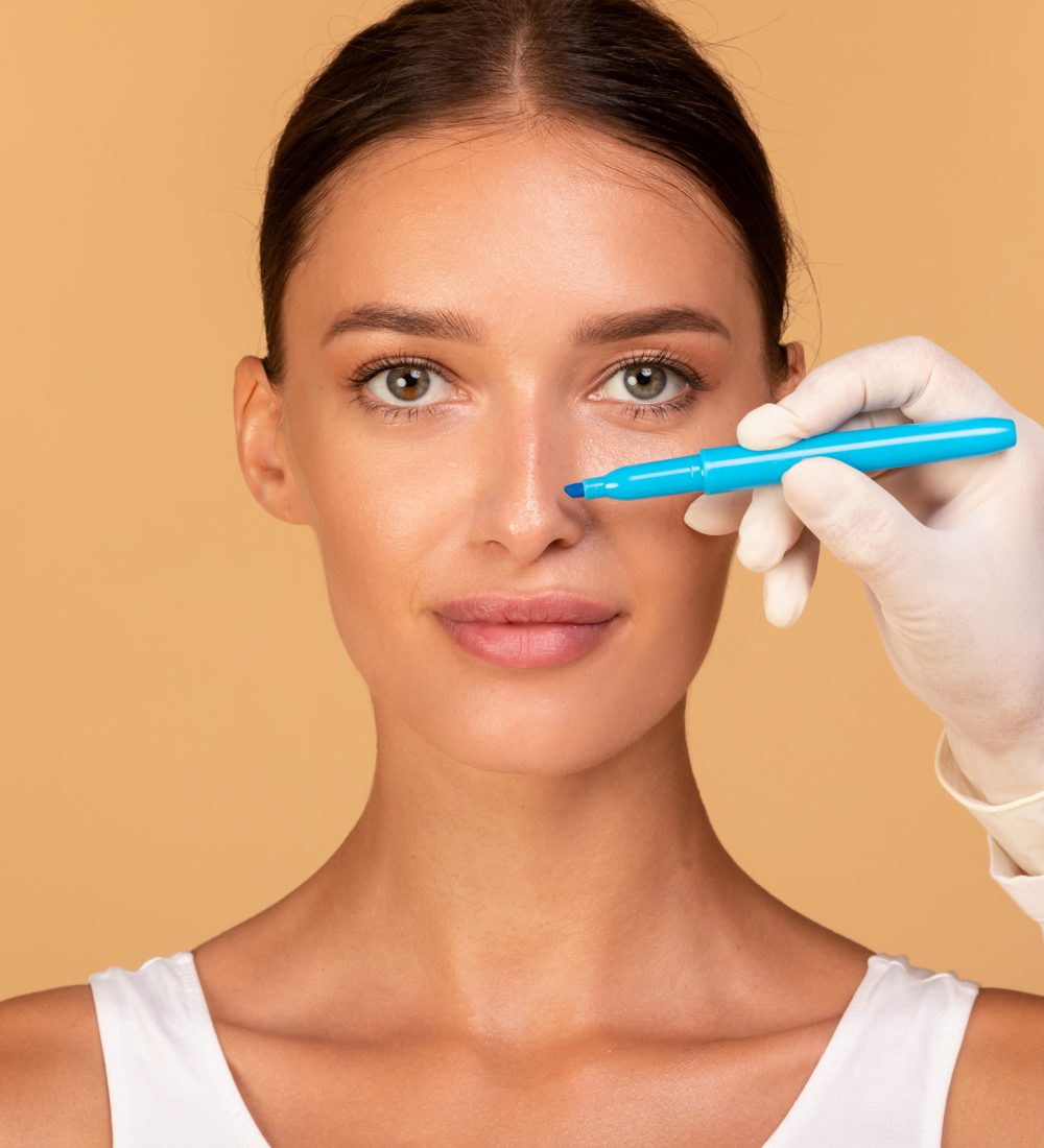 Rhinoplasty nose surgery Doctor making marks on patient's face, on consultation before facelift surgeon